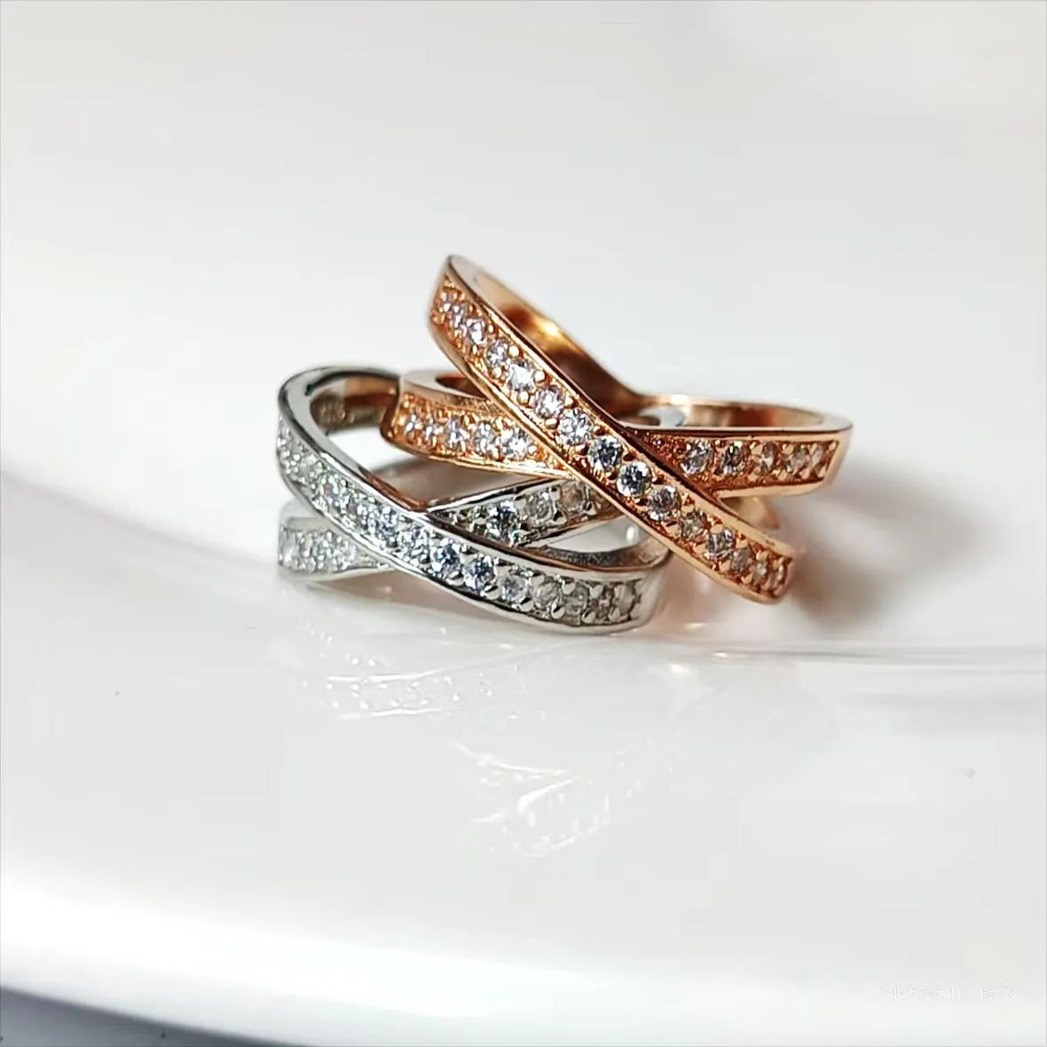 Silver and rose gold metal cross ring with micro-inlaid zircon, showing geometric and heart-shaped design.