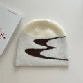 Acrylic knit beanie hat in black on a grey background, showing ribbed texture.