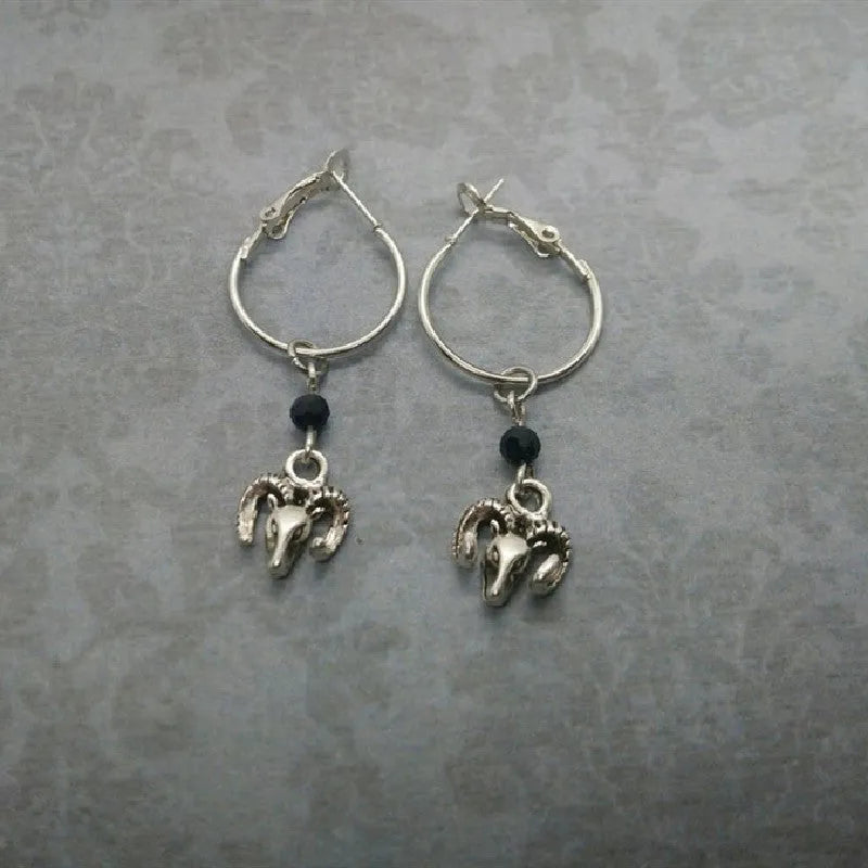 A pair of silver-coloured round alloy earrings featuring a Tibetan antelope design.