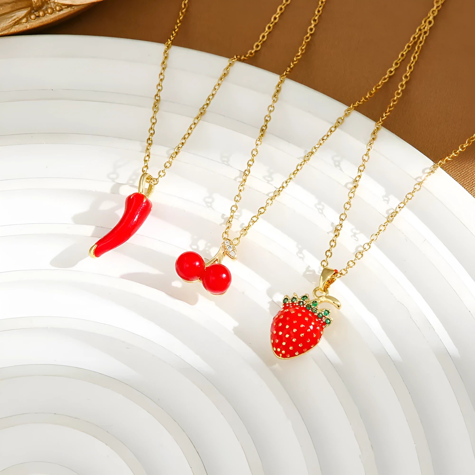Delicate titanium steel necklace with strawberry, cherry, or pepper charm on an O-ring chain in golden or zircon finishes.