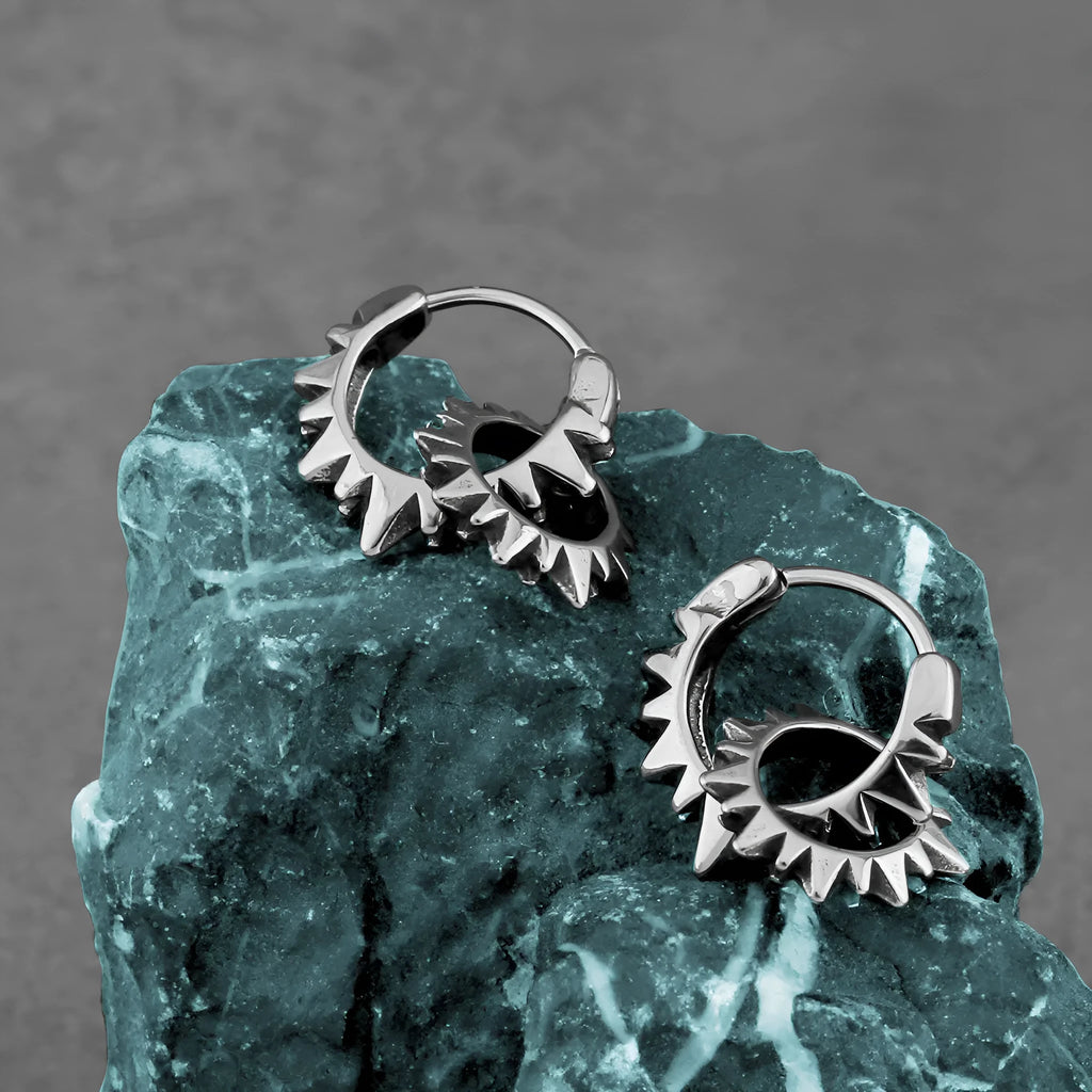 A pair of polished stainless steel round ring earrings with a steel colour finish on a white background.