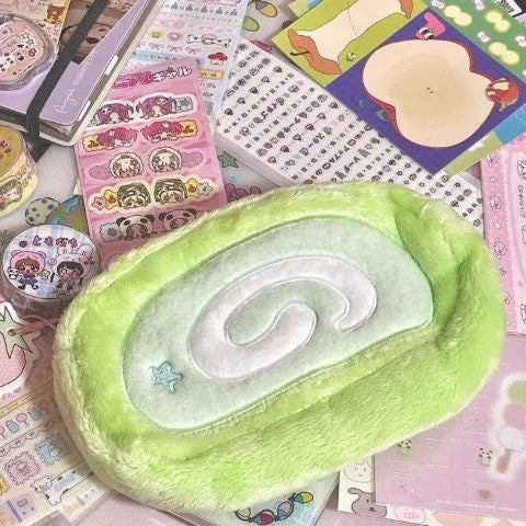 Swiss roll cake design pencil case in plush velvet with a zip closure.