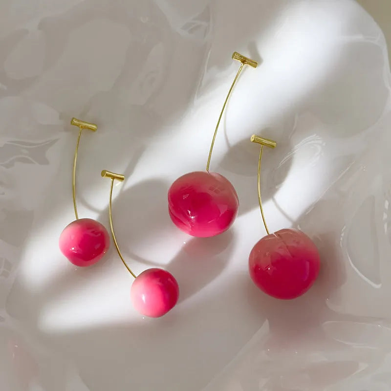 A pair of acrylic peach-shaped earrings with copper posts, shown in small and large size options.