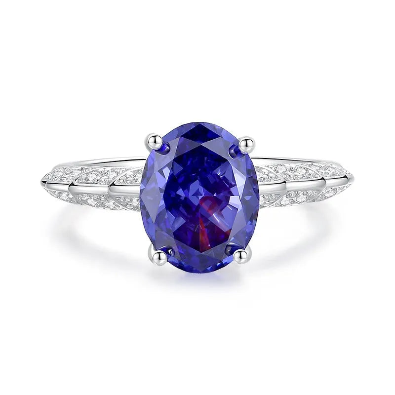 Close-up of a sterling silver heart-shaped ring with a floral-cut blue zircon stone.
