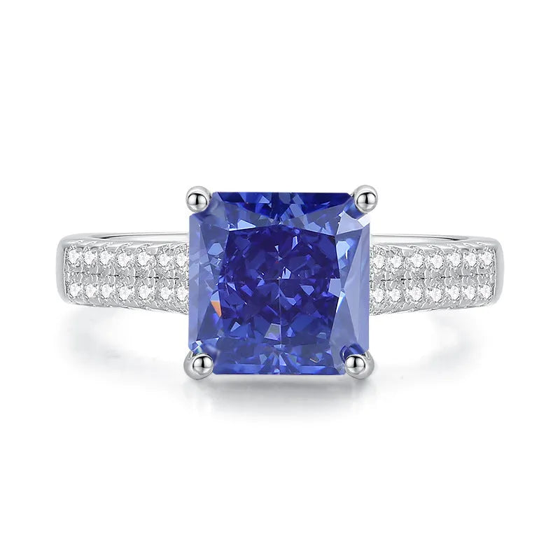 Close-up of a sterling silver heart-shaped ring with a floral-cut blue zircon stone.