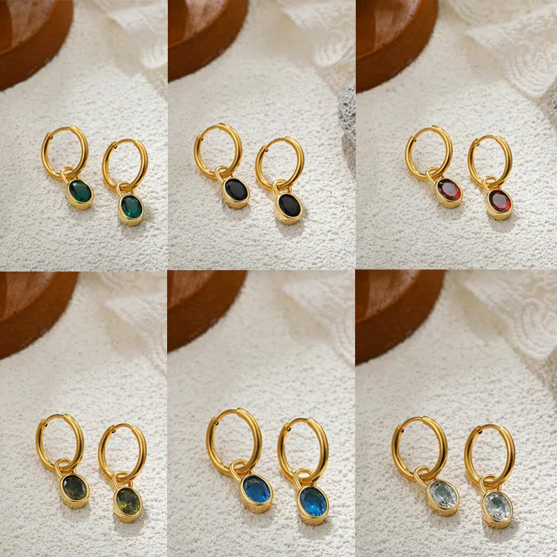 Close-up of a women's retro-style oval zircon drop earring in copper setting.