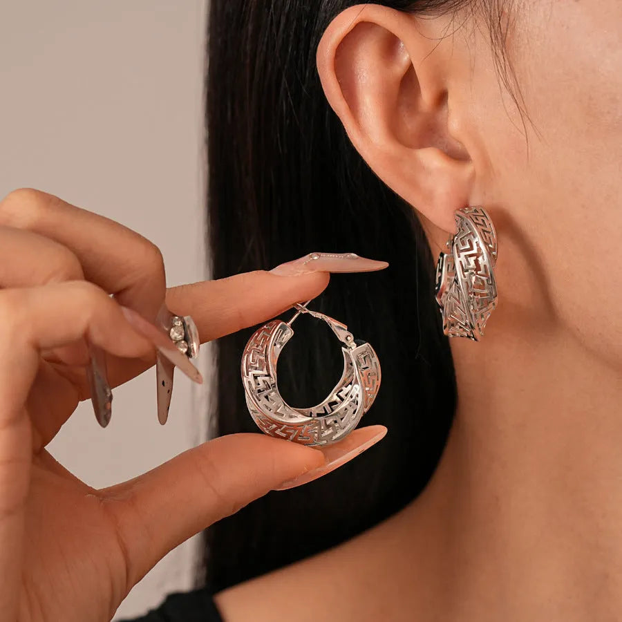 Women's geometric hollow stud earrings with twisted round shapes in gold and silver plating