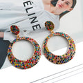 Colourful large round pendant drop earrings with cartoon style and diamond accents on metal alloy.