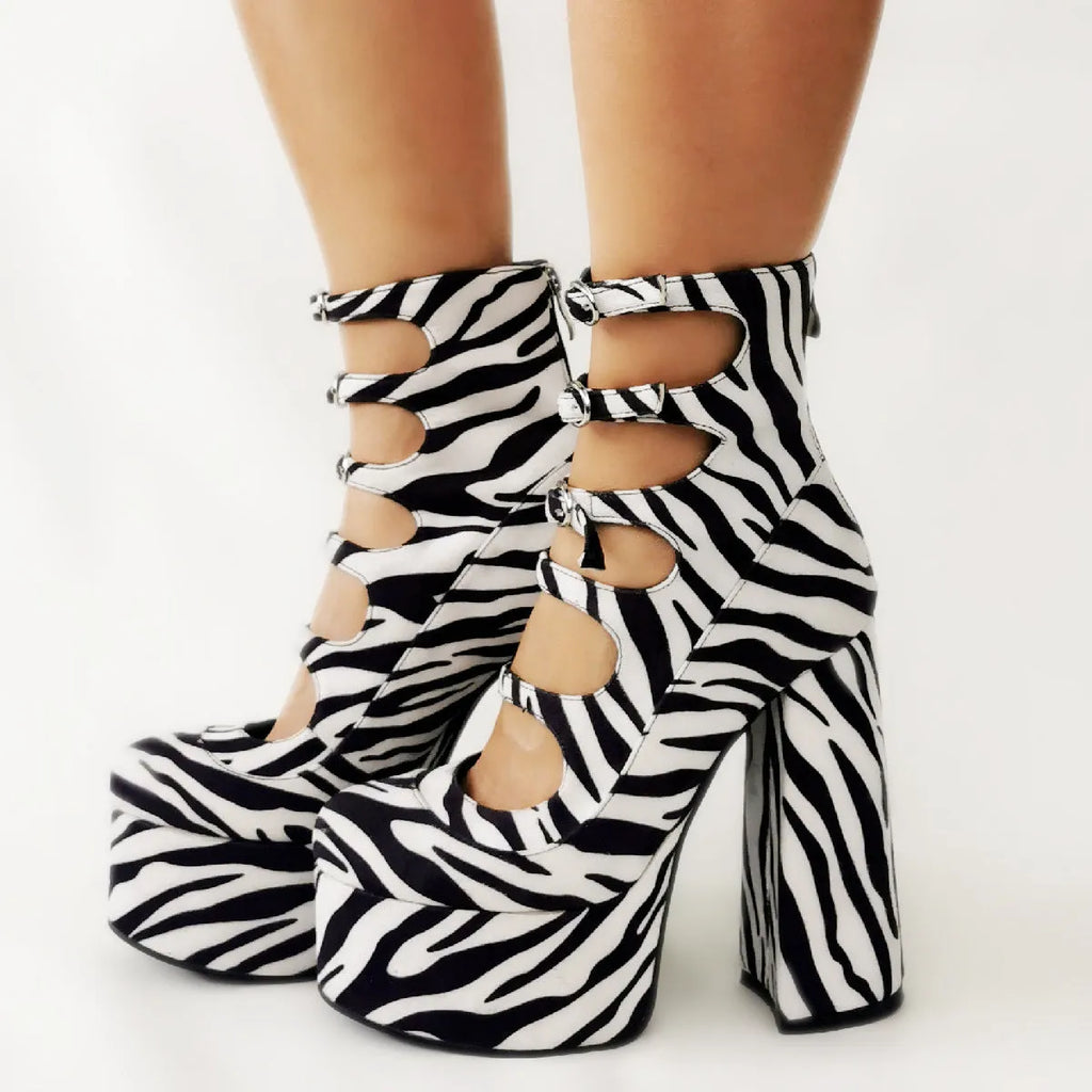 Black patent leather women's platform heel boots with a thick heel and a serpentine buckle strap.