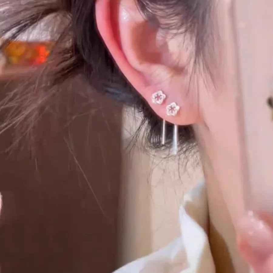 Silver colour hollow flower hanging earrings with petal design on female model