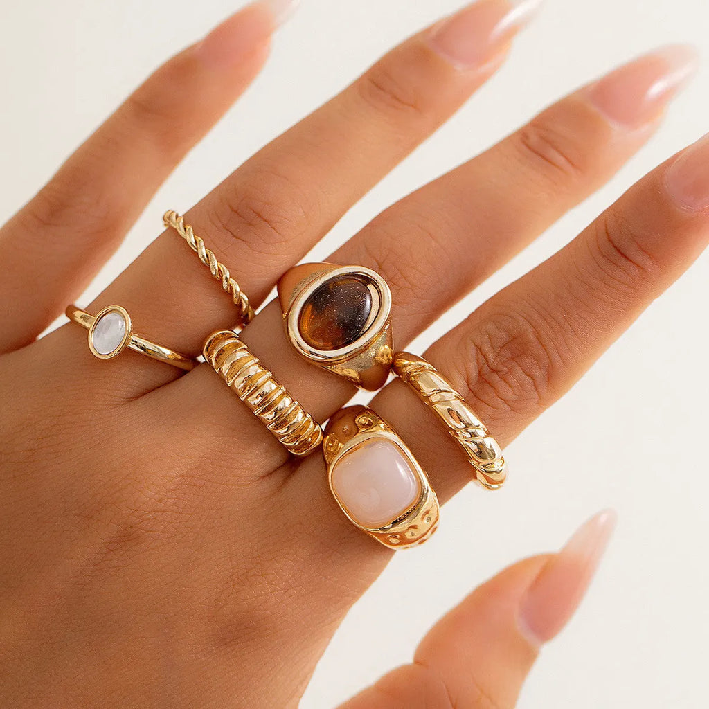 Light gold electroplated alloy ring set with six geometric and round designs for women