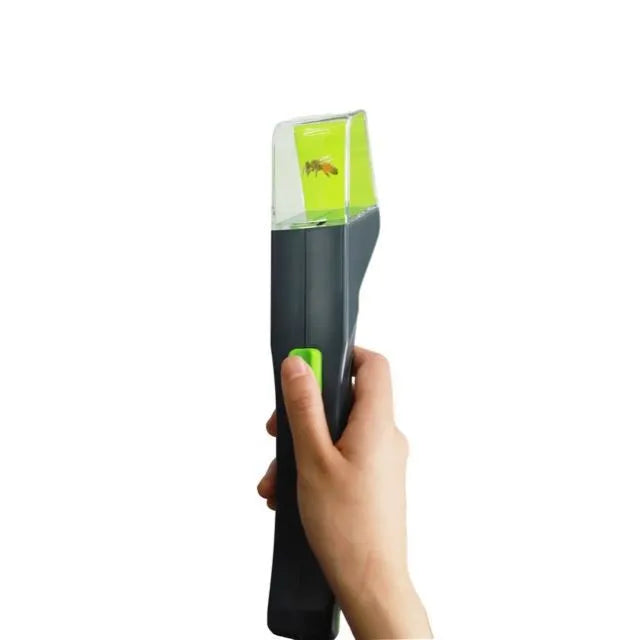 Green handheld plastic insect catcher for garden and lawn pest control.