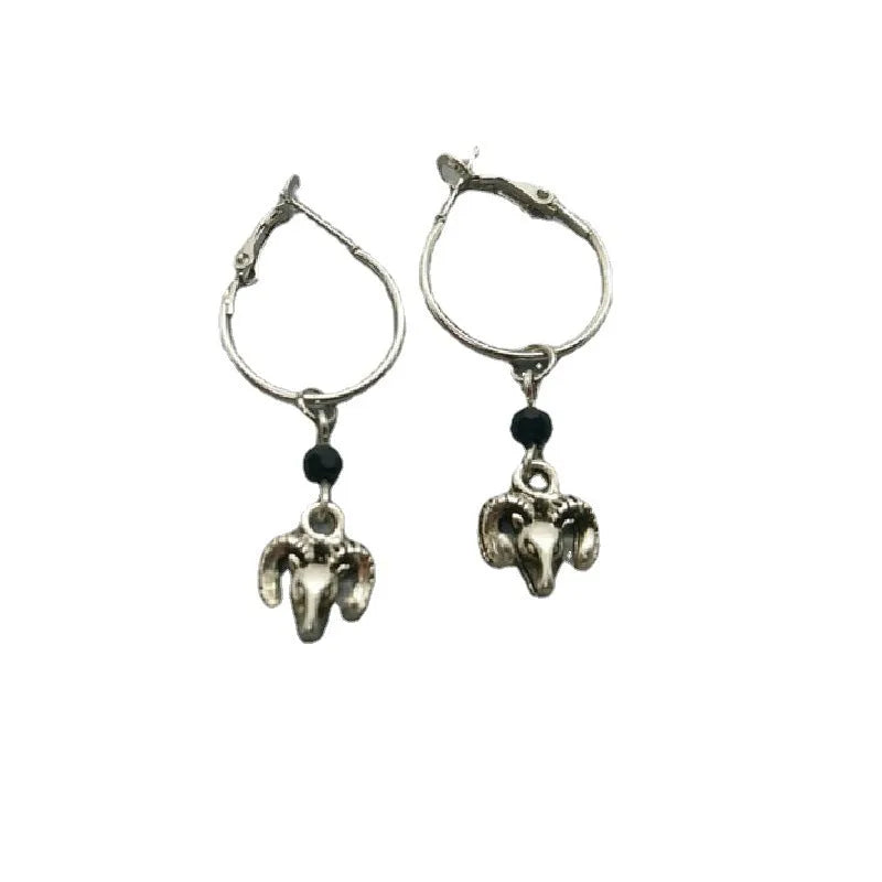 A pair of silver-coloured round alloy earrings featuring a Tibetan antelope design.