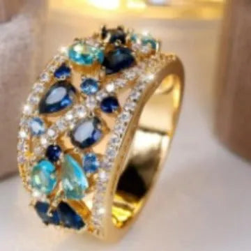 Women's hollow round fashion ring in gold or platinum finish with sapphire blue or white diamond accents