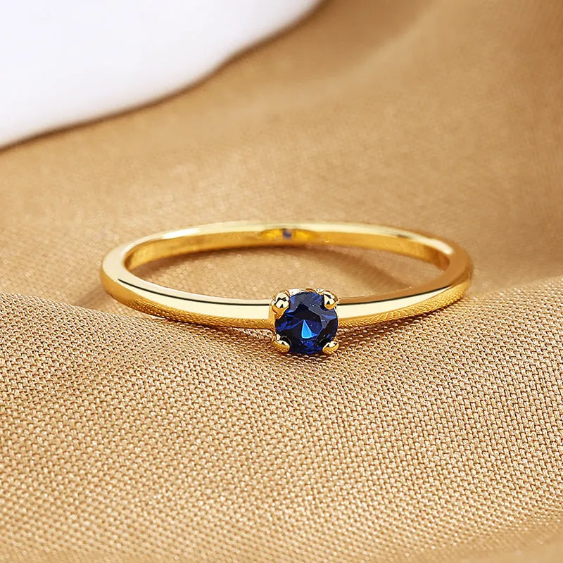 Copper geometric circle women's ring with a single diamond, shown in blue, green, red, and white colour options.
