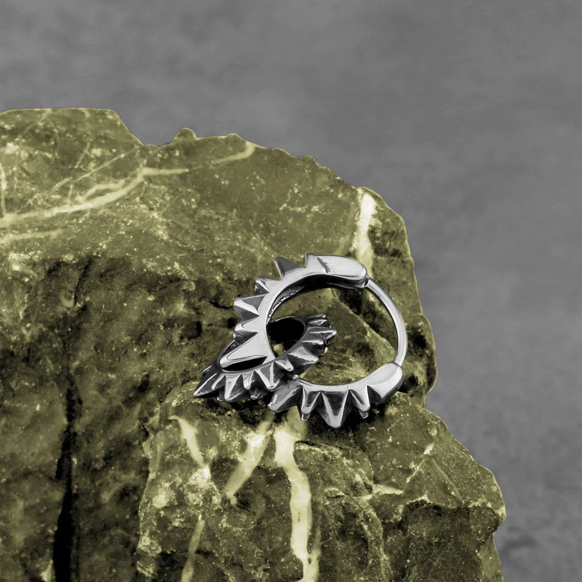 A pair of polished stainless steel round ring earrings with a steel colour finish on a white background.