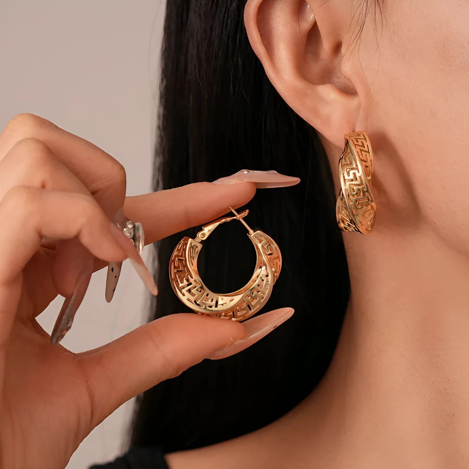 Women's geometric hollow stud earrings with twisted round shapes in gold and silver plating