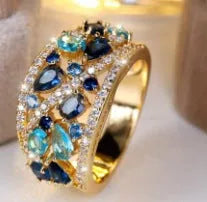 Women's hollow round fashion ring in gold or platinum finish with sapphire blue or white diamond accents