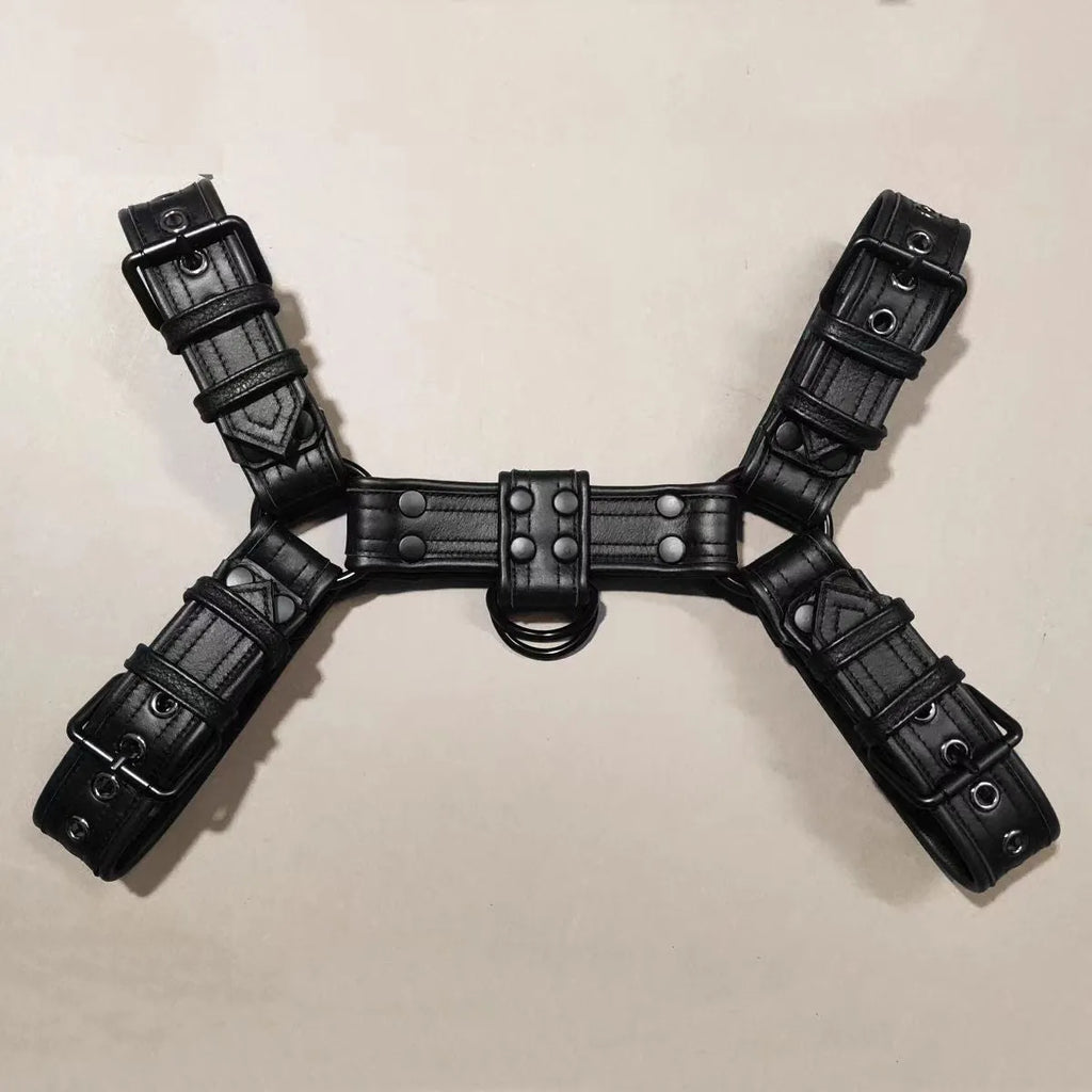Black leather chest bondage strap with metal buckles on male torso