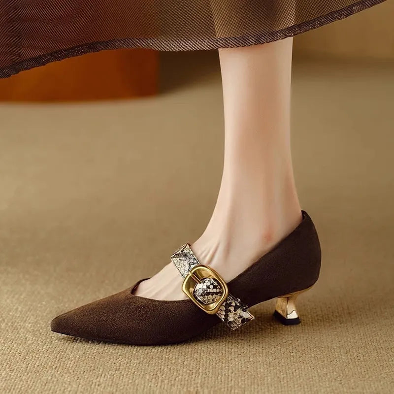 Women's black low-cut pointed stiletto heels with a silver buckle fastening on the ankle strap.