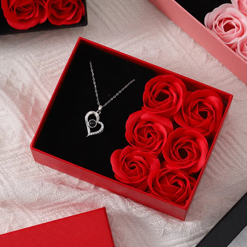 Red Korean style gift box open to show six pink soap flowers, with a matching handbag, for Valentine's Day.