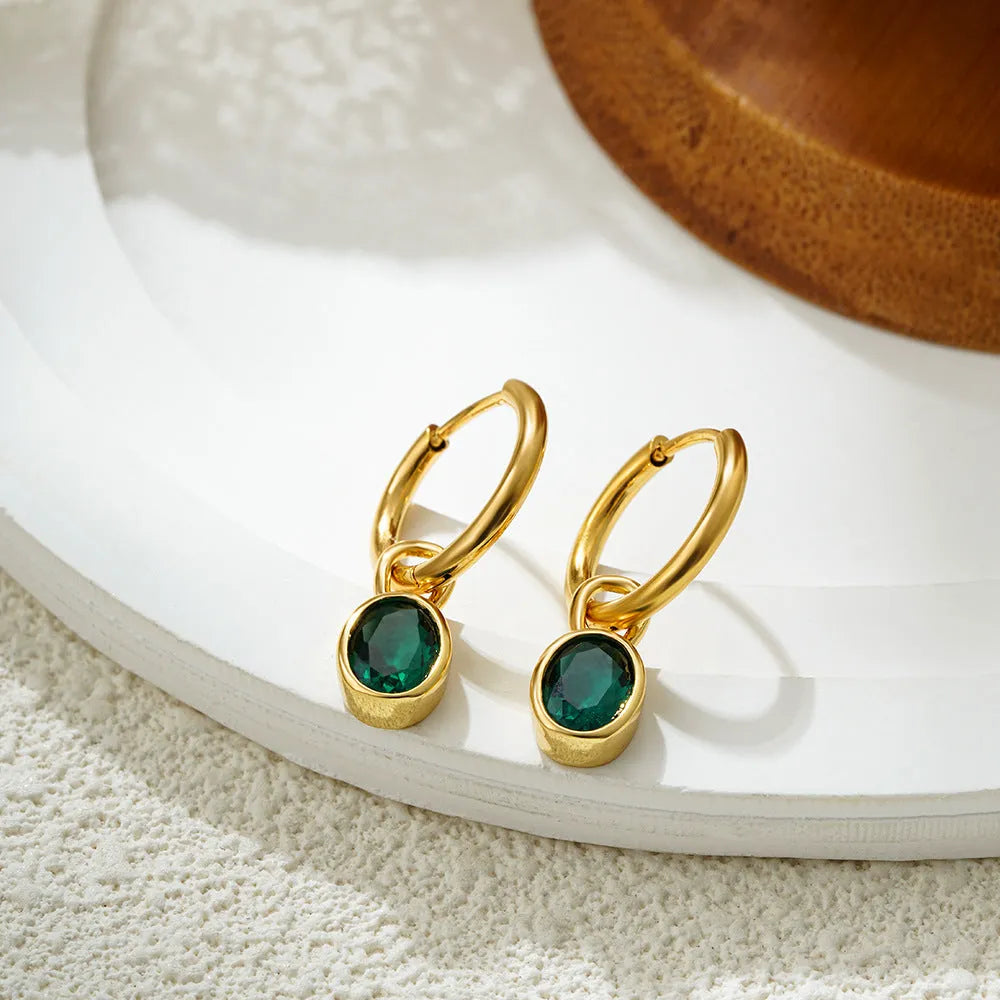 Close-up of a women's retro-style oval zircon drop earring in copper setting.