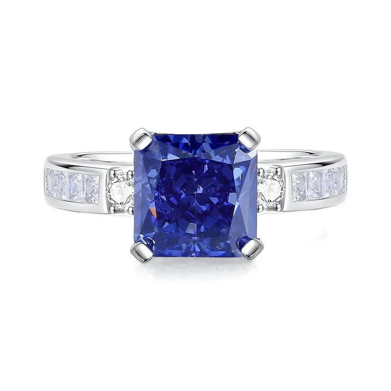 Close-up of a sterling silver heart-shaped ring with a floral-cut blue zircon stone.