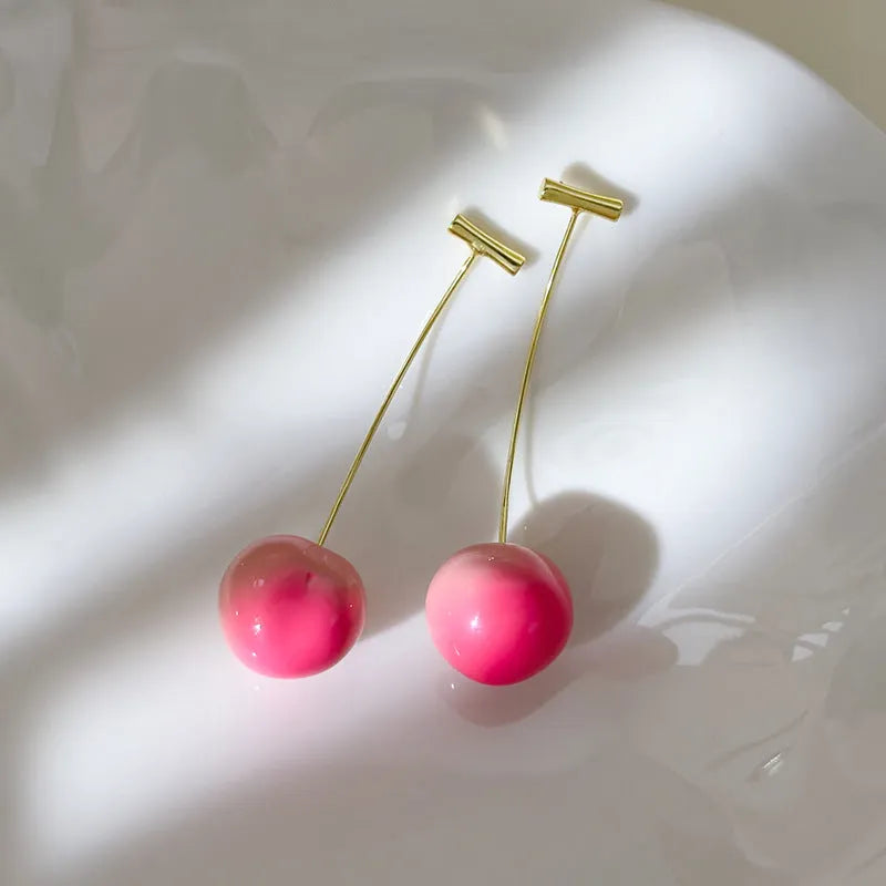 A pair of acrylic peach-shaped earrings with copper posts, shown in small and large size options.