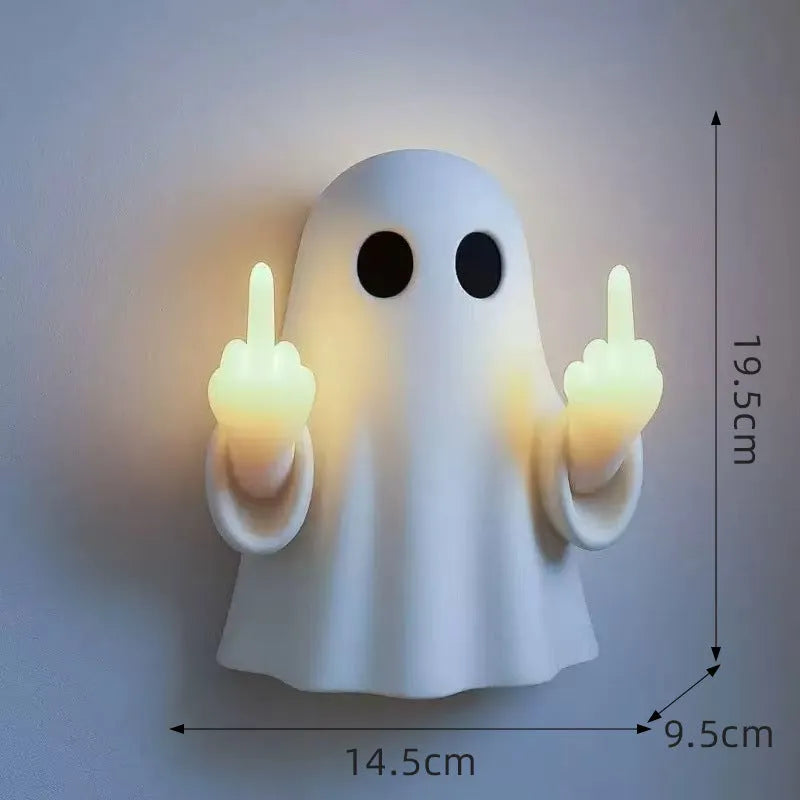 White ghost statue night lamp with LED light on a dark table.