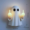 White ghost statue night lamp with LED light on a dark table.