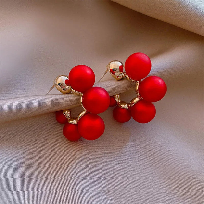 A pair of red bell charm earrings made from alloy metal with a silver tone finish.