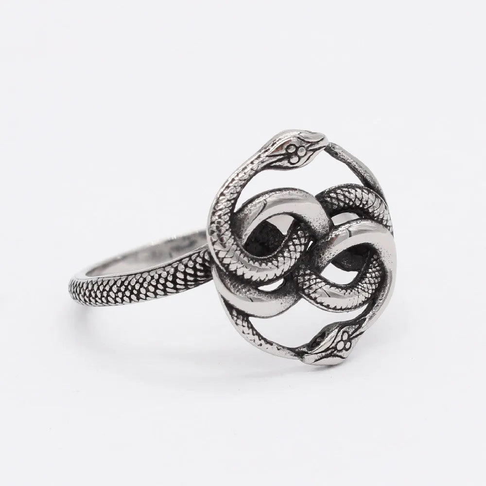 Close-up of a titanium steel double snake ring in retro style on a grey background