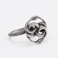 Close-up of a titanium steel double snake ring in retro style on a grey background
