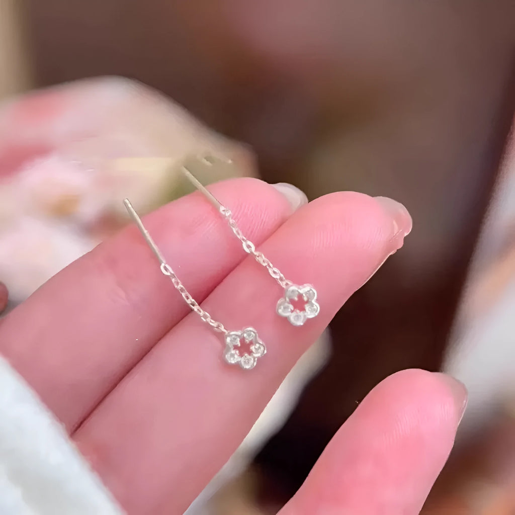 Silver colour hollow flower hanging earrings with petal design on female model
