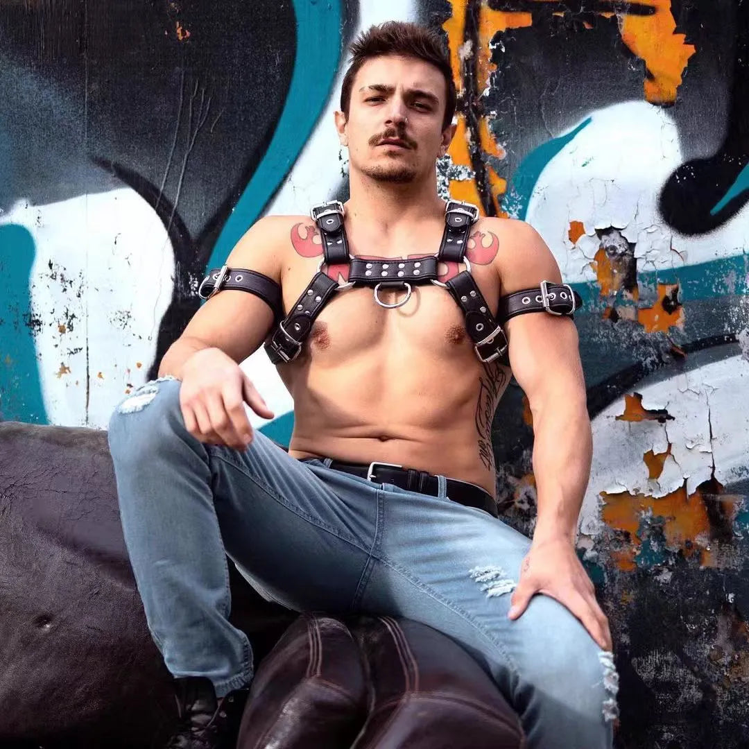 Black leather chest bondage strap with metal buckles on male torso