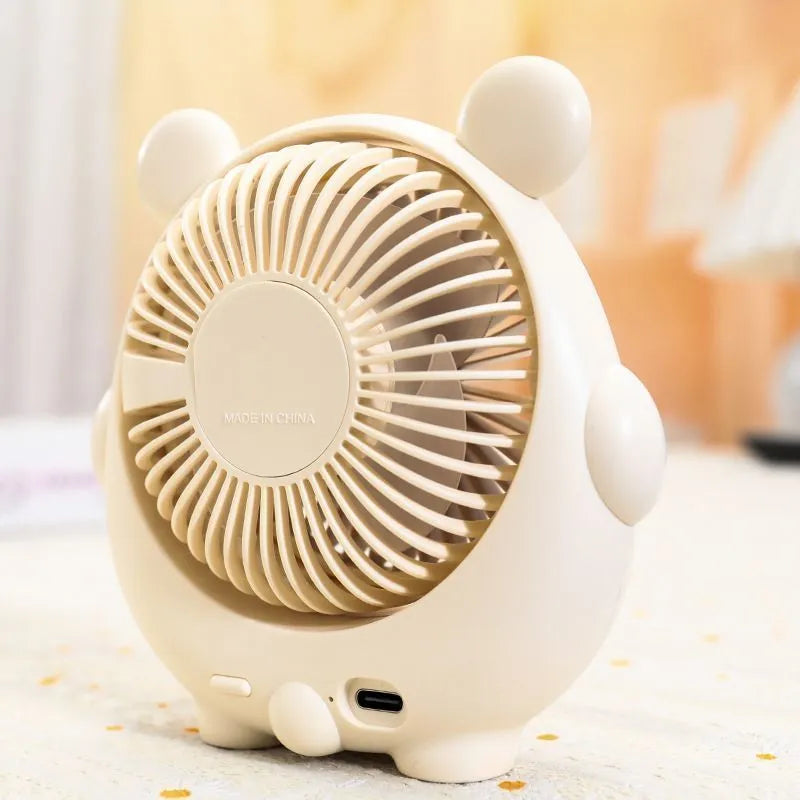 Cute dog design USB desktop electric fan in bear apricot colour on a wooden desk.