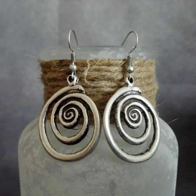 Silver geometric spiral earrings with distressed finish, measuring 2.6 by 5 centimetres