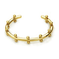 Close-up of a C-shaped stainless steel bean bead with textured rivet design, next to an alloy bracelet.
