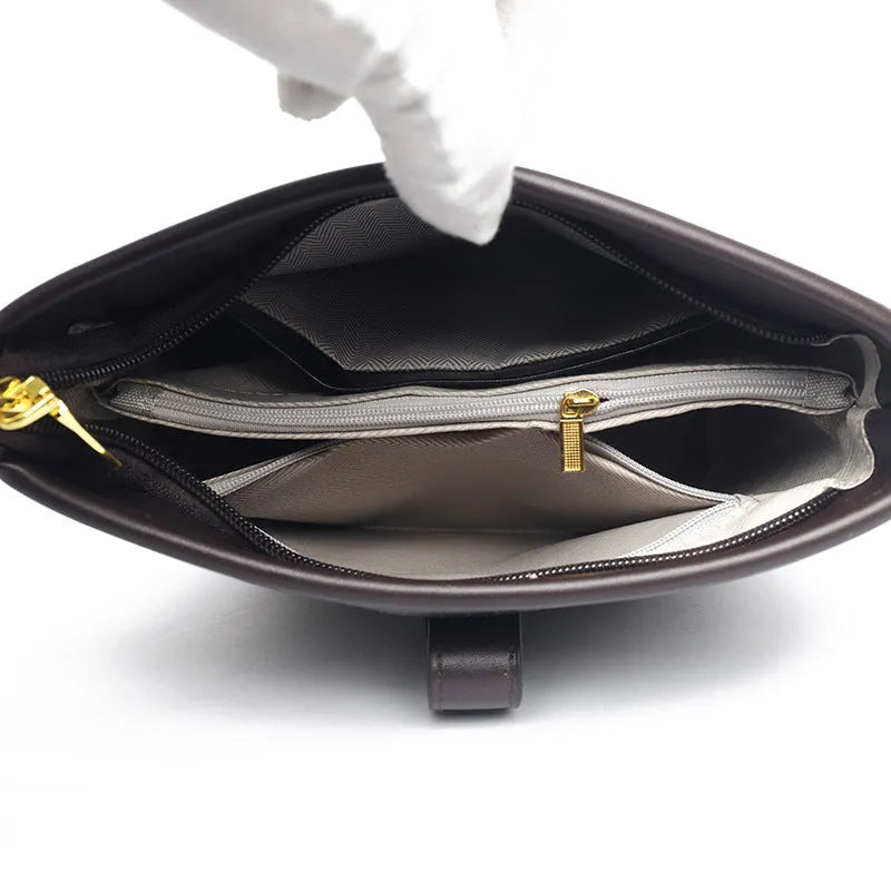 Soft black PU bucket style messenger bag with double shoulder straps, shown open to reveal internal organiser pockets.