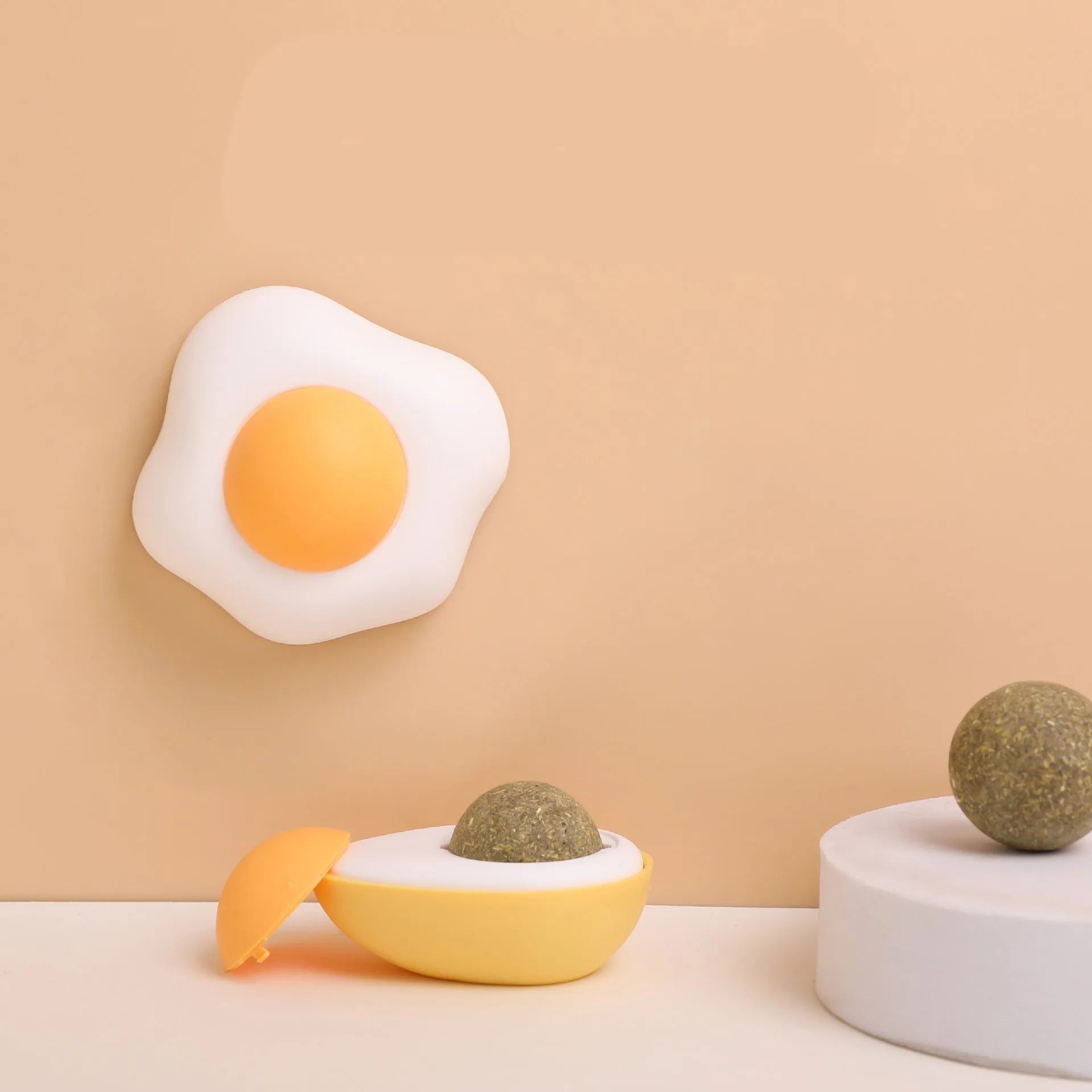 Catnip ball toy in fried egg and poached egg shapes with adhesive backing for wall and floor play