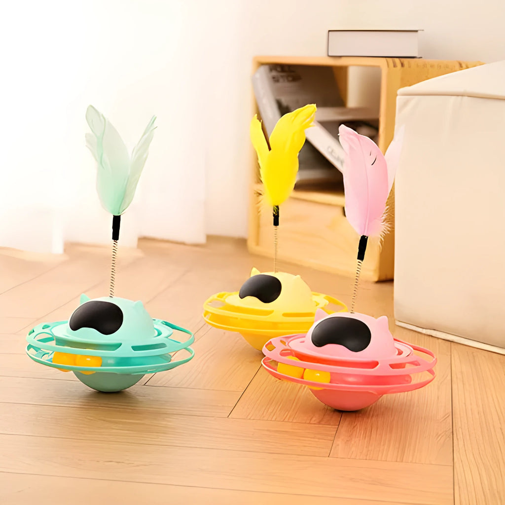 Pink plastic cat tumbler turntable toy with stick and ball on a flat surface.