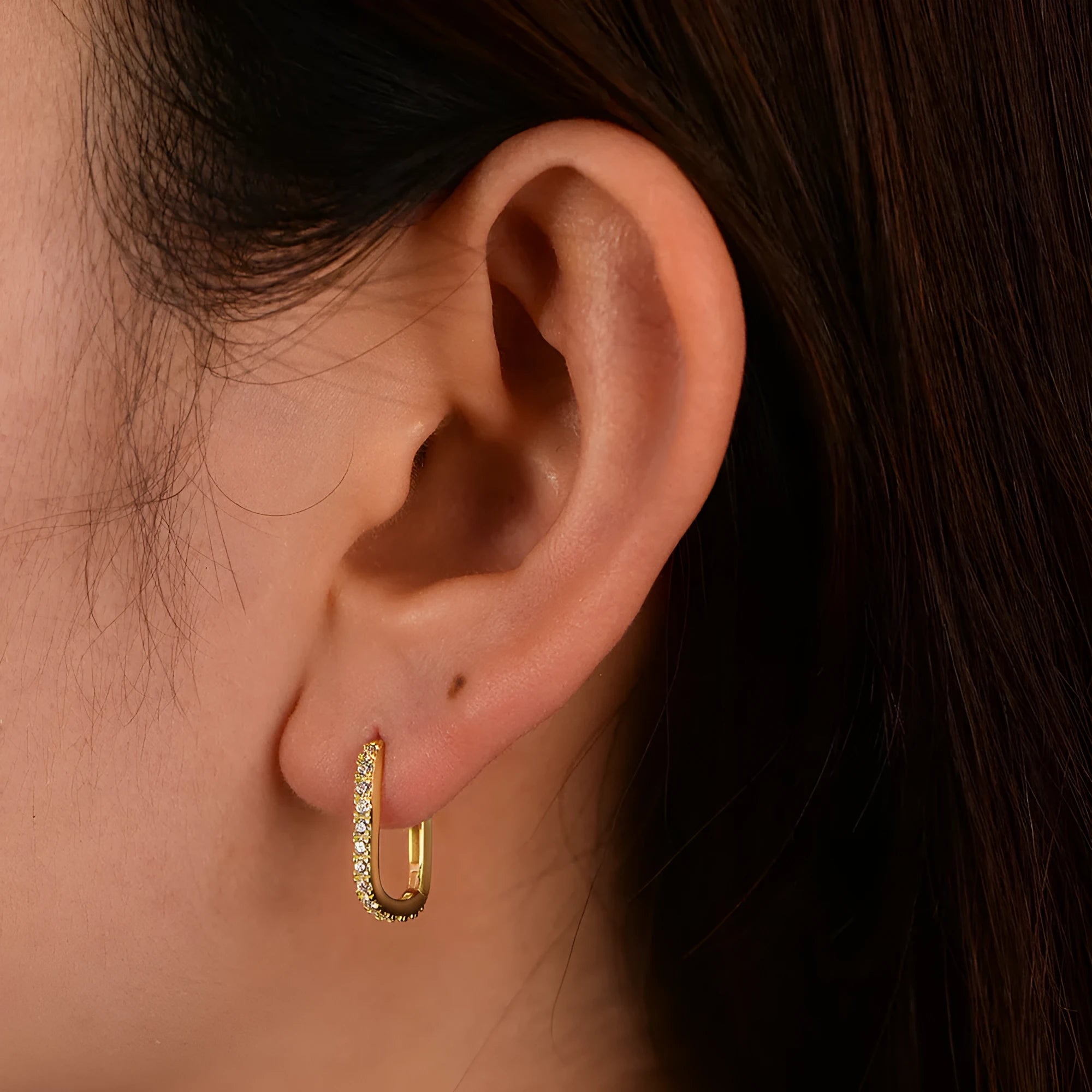 A pair of oval zircon clip earrings in sterling silver, shown in yellow and white finish options.