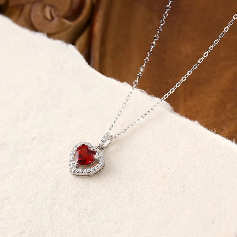 Sterling silver heart pendant necklace with a natural gemstone on an adjustable cross chain.