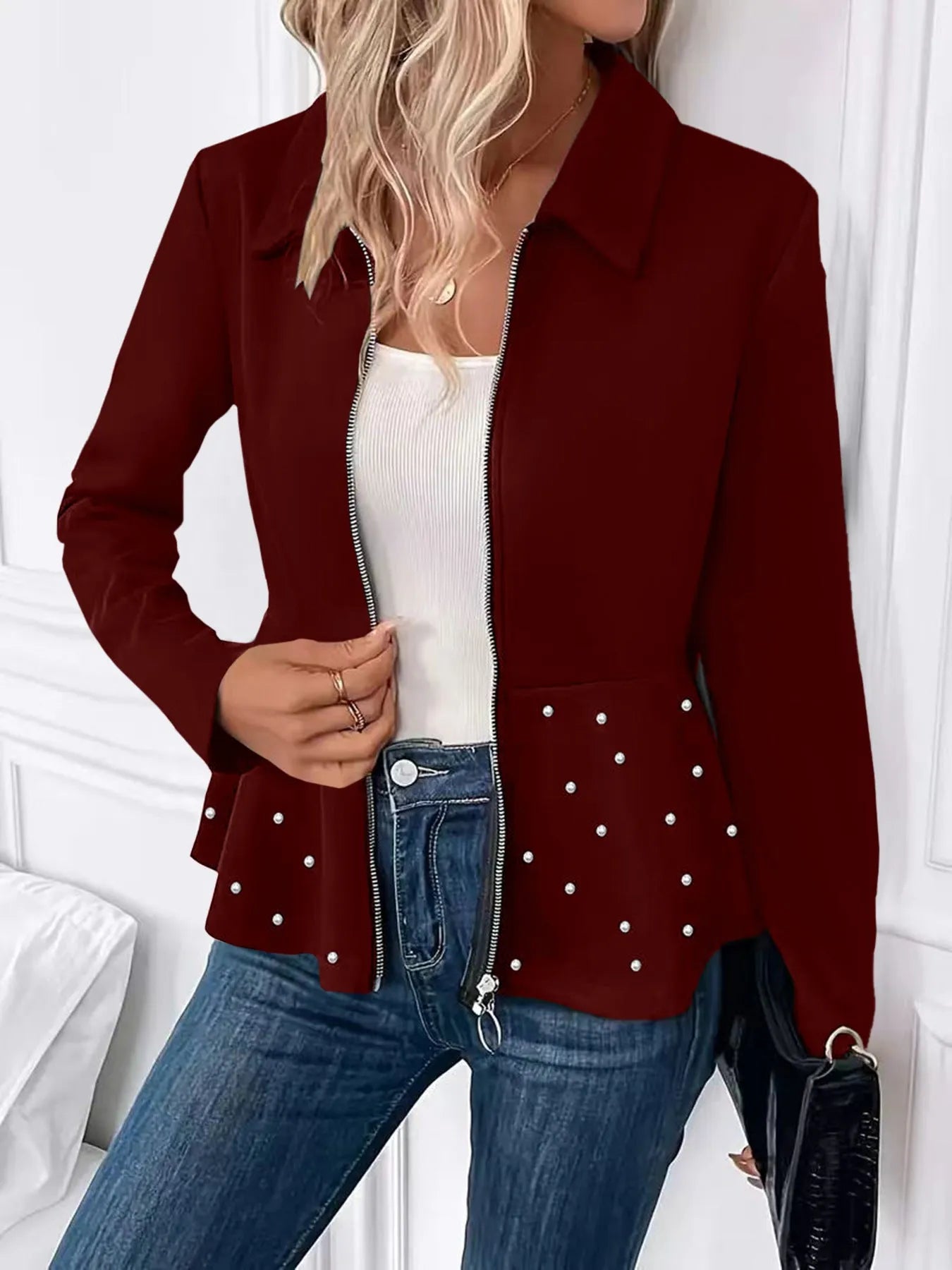 Women's loose fit black coat with beaded heavy-duty zipper and ruffled hem detail.