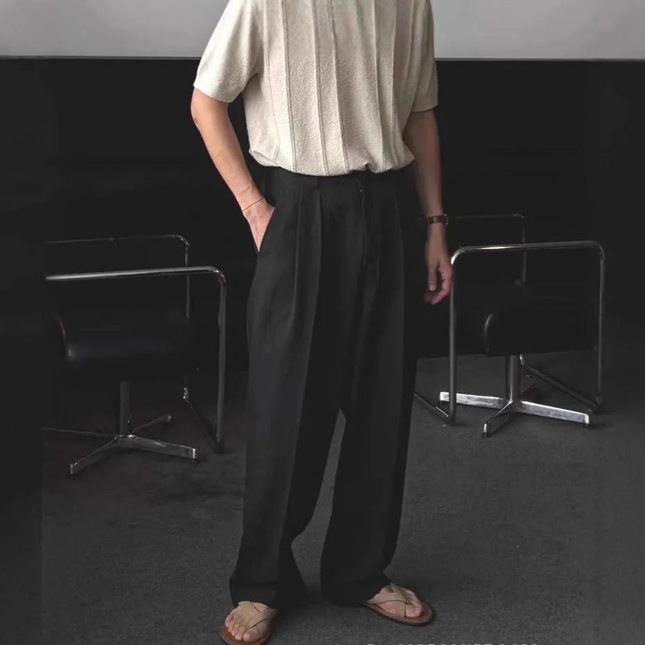 Man wearing loose apricot wide-leg cotton linen blend trousers with a pencil-leg opening.