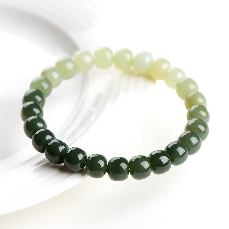 Natural Hetian jade bracelet showing gradient water colour and polished oval beads.
