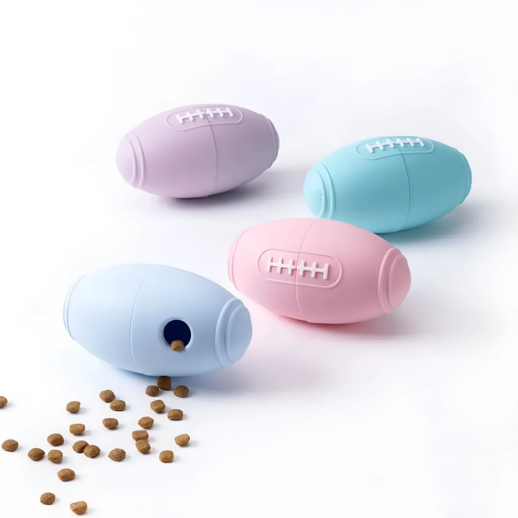 Silicone rugby-shaped dog toy with food leak hole, available in blue, light blue, pink, and purple.