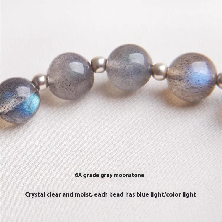 Women's bracelet with pink strawberry quartz and grey moonstone beads on a sterling silver chain with a charm.