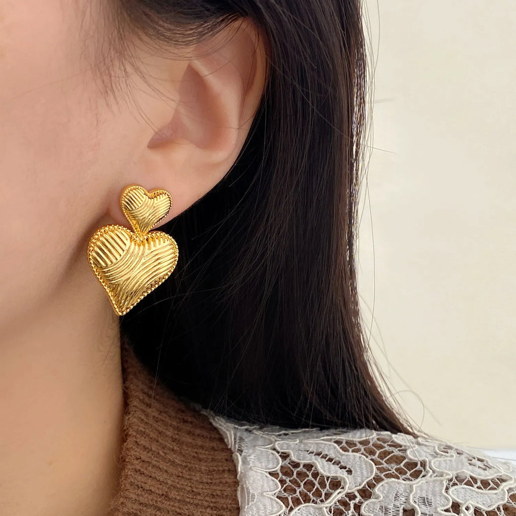 Double heart earrings in copper with electroplating, shown as ear clips or ear studs for women, one pair.