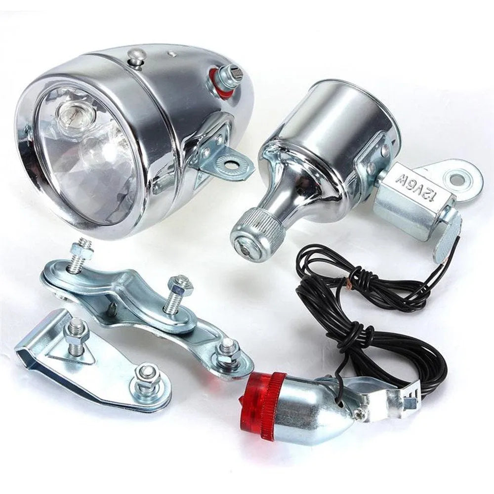 Silver bicycle dynamo generator light kit showing generator unit, wiring, and connectors for front or rear mounting.